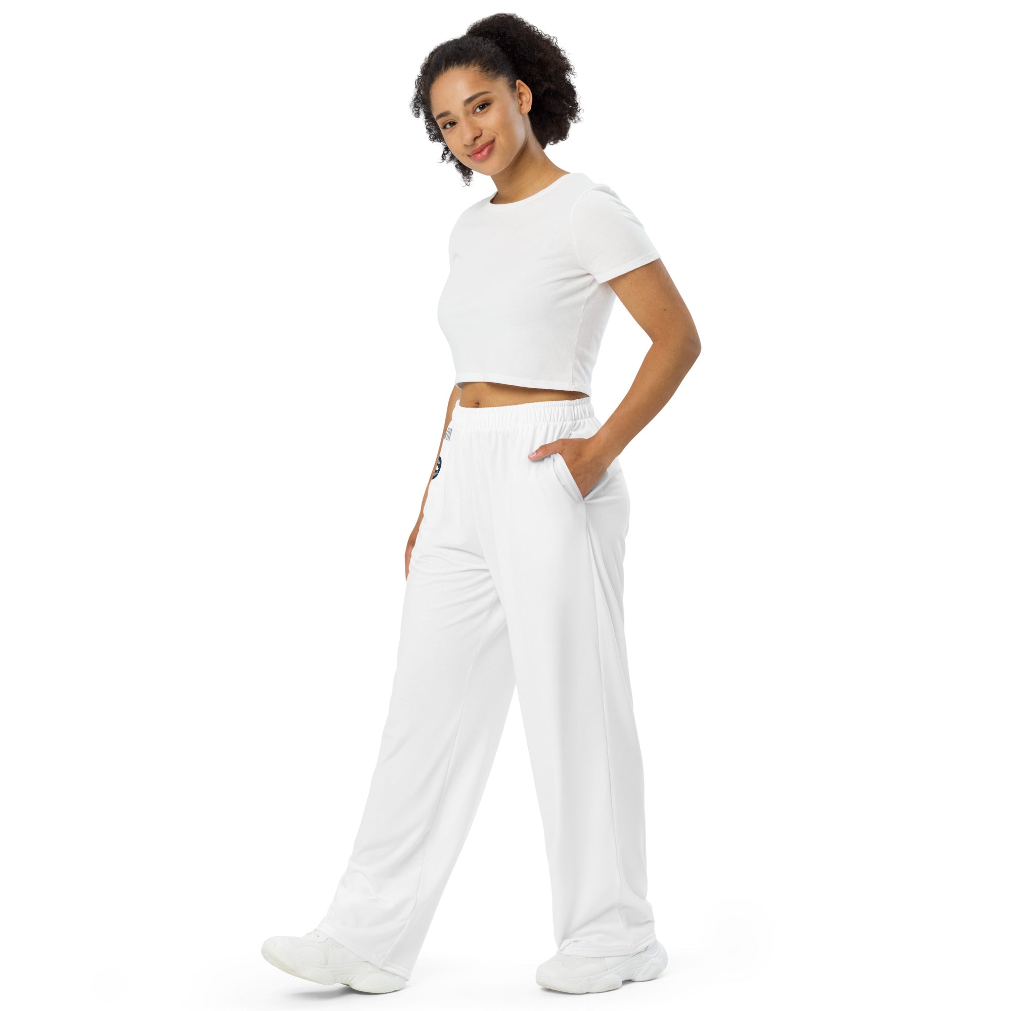 Person wearing a white crop top and white sweatpants on a white background