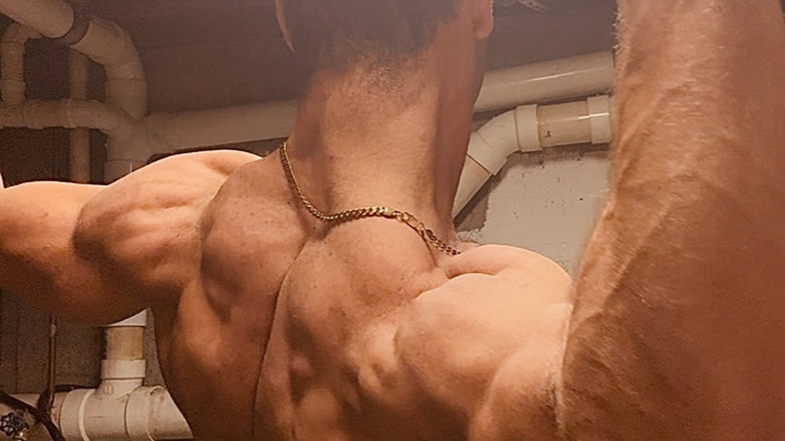 Chris McGrath flexing his back and shoulders in a basement gym, representing strength, discipline, and the bold visual identity behind the Daddy Mustache brand and chaos marketing strategy.