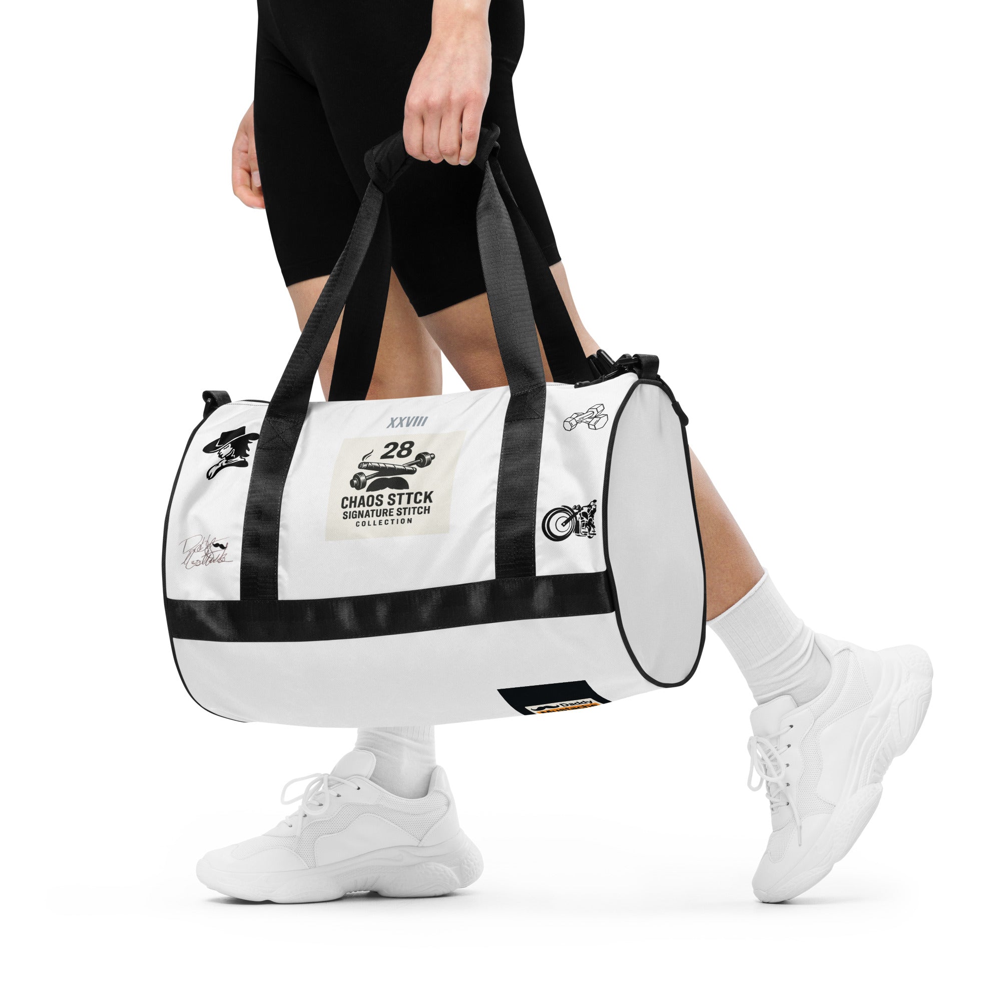 White duffel bag with black accents held by a person on a white background