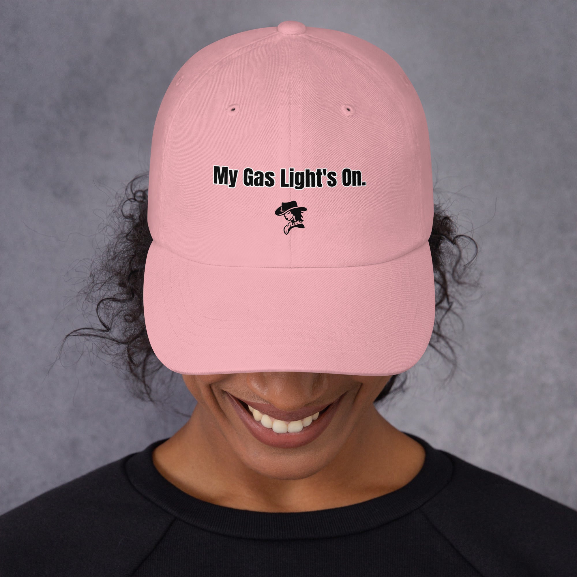 Person wearing a pink cap with 'My Gas Light's On.' text on a gray background