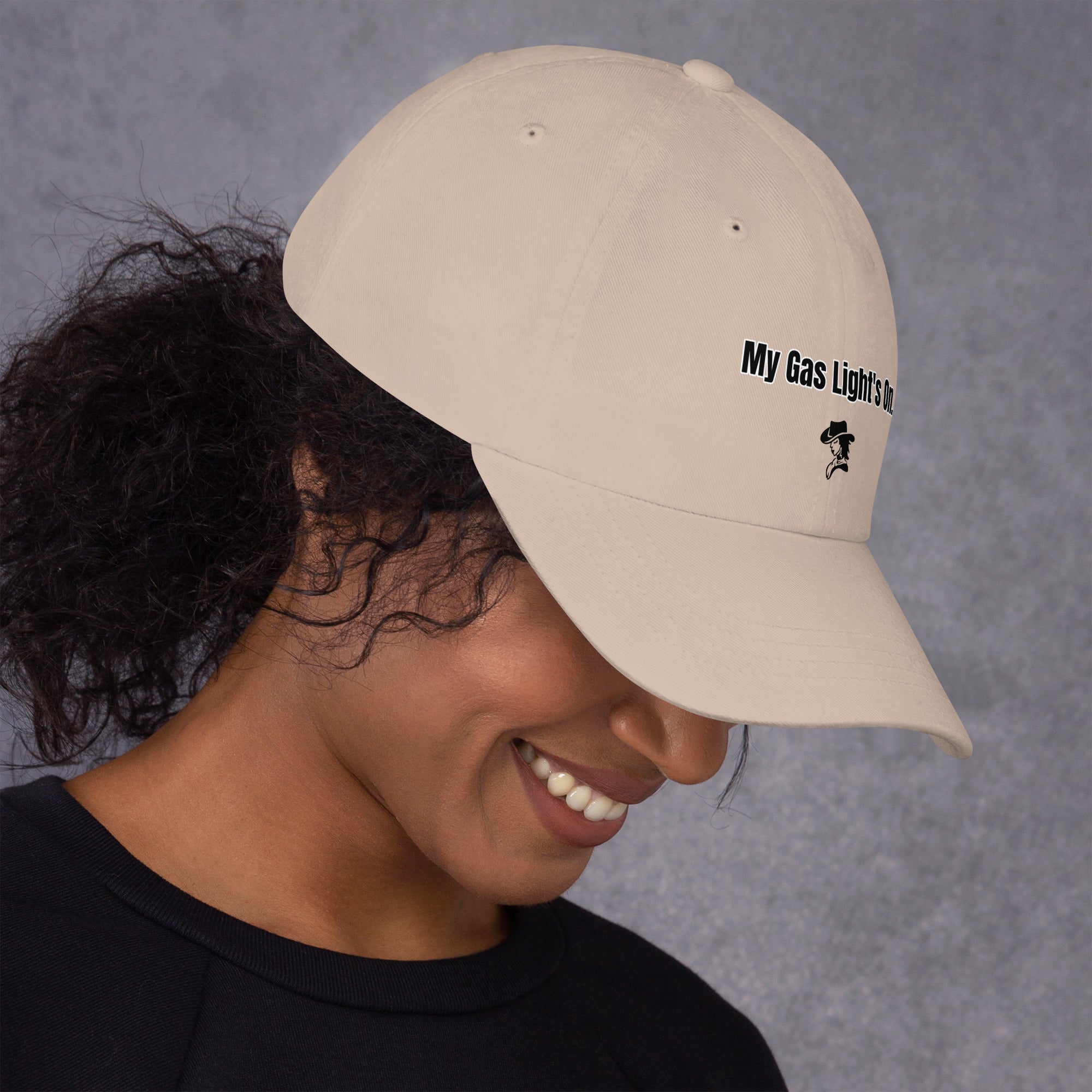 Person wearing a beige cap with text and logo on a gray background